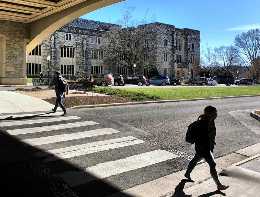 students walking under Torg bridge